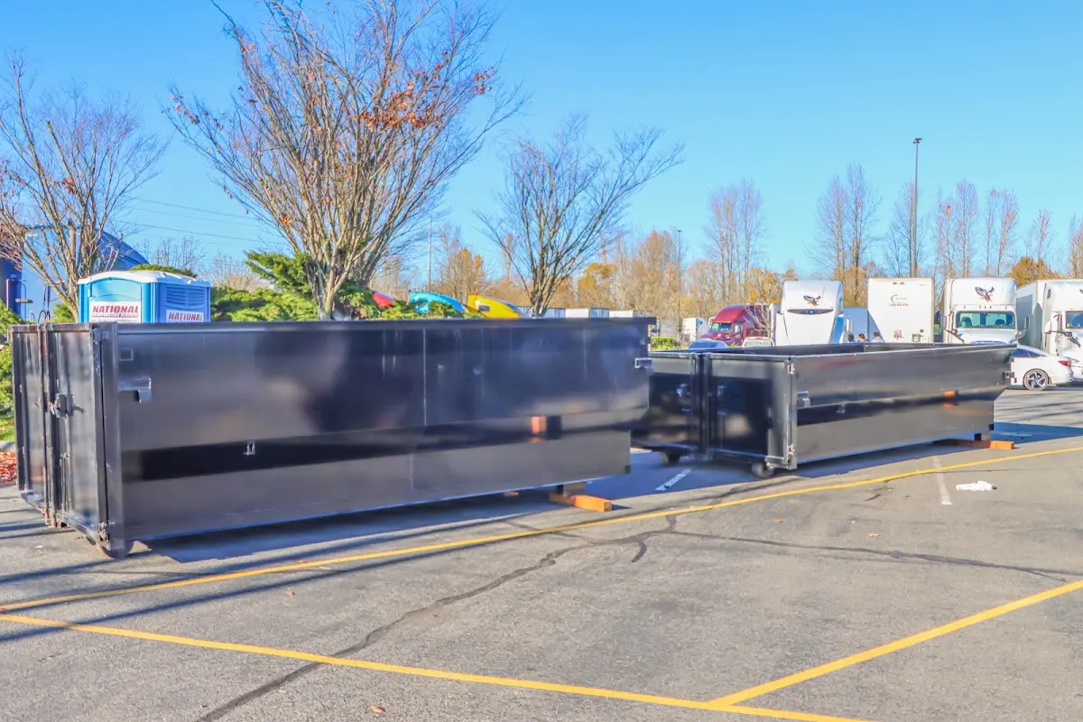 Professional dumpster rental service with roll-off container on residential driveway in Montrose